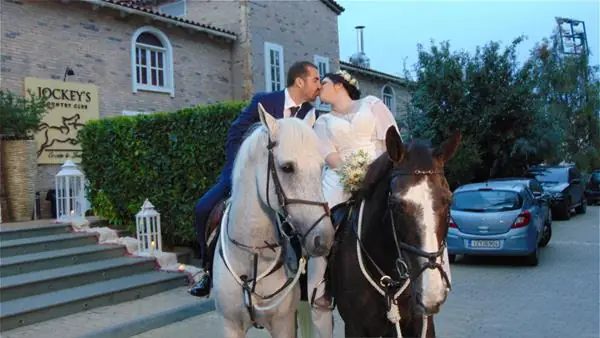 Bride and groom on horses at the entrance