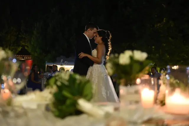 Bride and groom among candles in the garden
