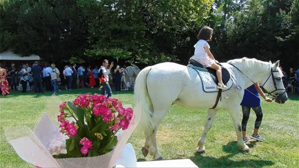 Child on a white horse at a baptism