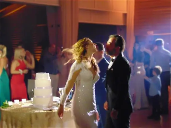 Couple dancing beside the cake